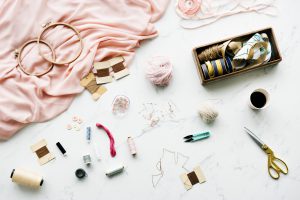 needle sewing handmade objects on marble table