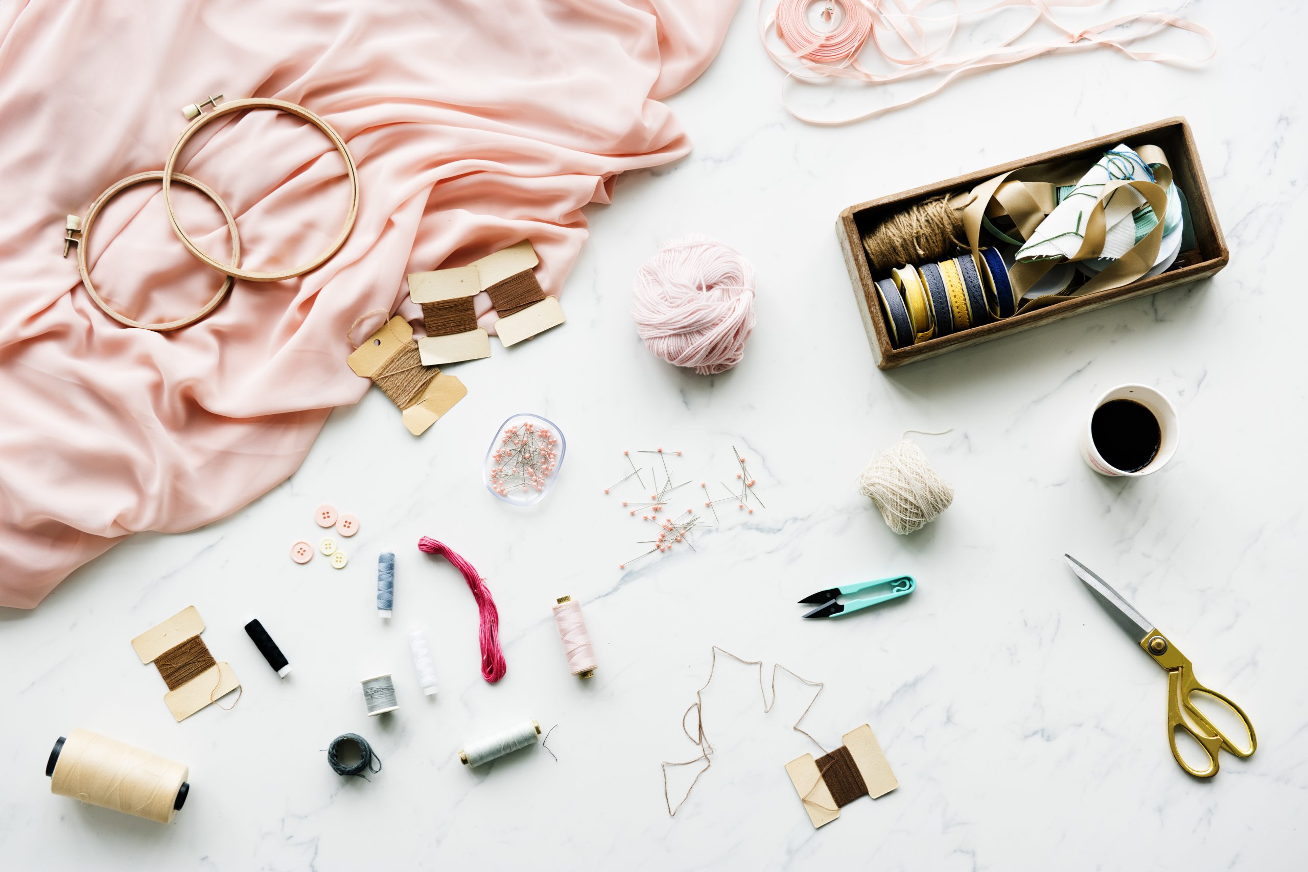 needle sewing handmade objects on marble table